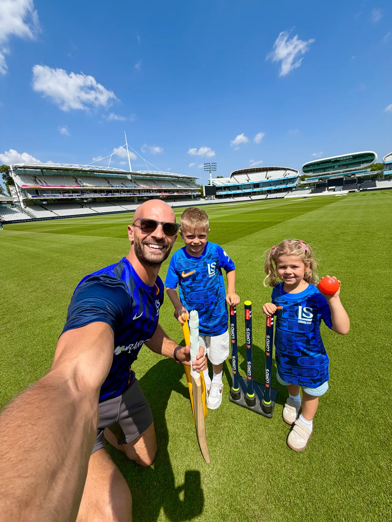 Daniel with Joshua and family on the outfield at a cricket ground